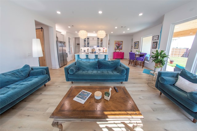 living room with a chandelier and light hardwood / wood-style floors