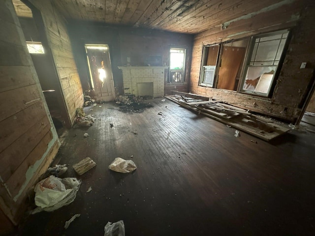 miscellaneous room featuring a brick fireplace, hardwood / wood-style flooring, and wooden ceiling