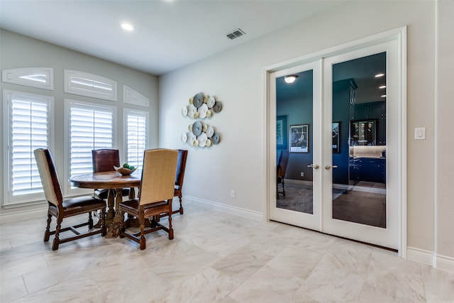 dining room featuring french doors and tile patterned flooring