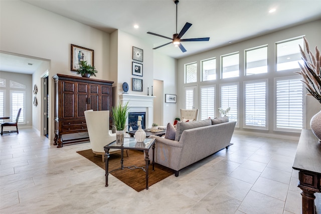 tiled living room featuring ceiling fan and a high ceiling