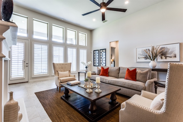 living room with light tile patterned floors, ceiling fan, and a high ceiling