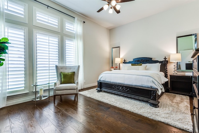 bedroom with hardwood / wood-style floors, multiple windows, a ceiling fan, and baseboards