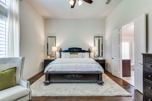 bedroom with dark wood-style floors, visible vents, ceiling fan, and baseboards