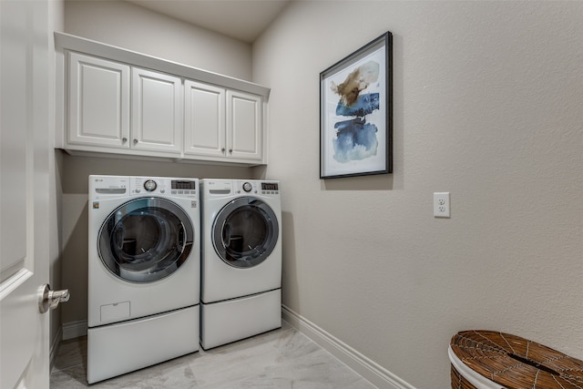 washroom featuring light tile patterned floors, cabinets, and washing machine and clothes dryer