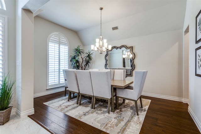 dining room featuring hardwood / wood-style flooring, vaulted ceiling, and a chandelier