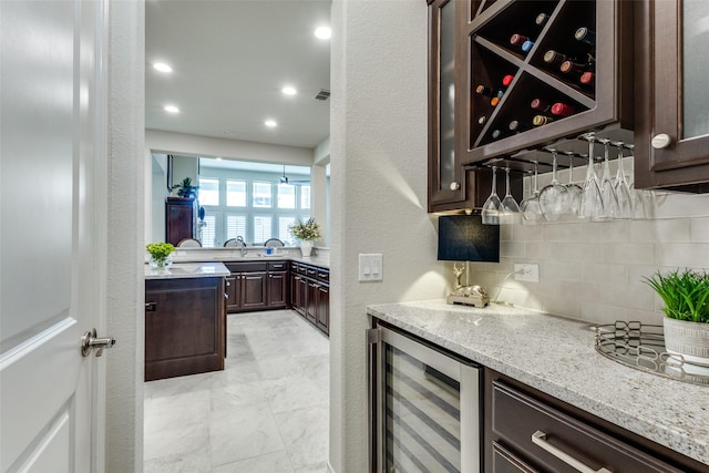 bar with a dry bar, visible vents, decorative backsplash, a textured wall, and wine cooler