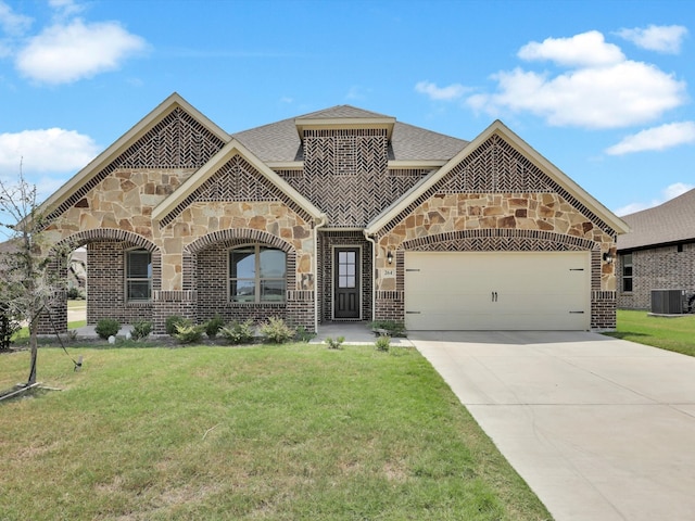 mediterranean / spanish home with a garage, a front yard, and central AC unit