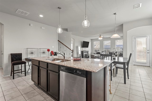 kitchen featuring dishwasher, sink, ceiling fan, light tile patterned floors, and an island with sink