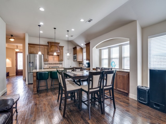 dining room featuring vaulted ceiling, dark hardwood / wood-style floors, and plenty of natural light