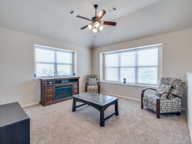 living room with ceiling fan, lofted ceiling, and light carpet