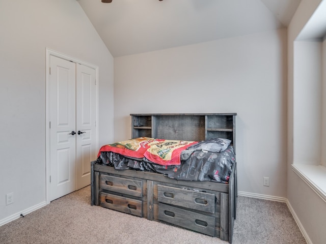 bedroom with a closet, vaulted ceiling, and light colored carpet