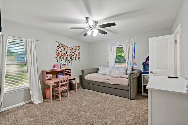 bedroom with light colored carpet, ceiling fan, and multiple windows