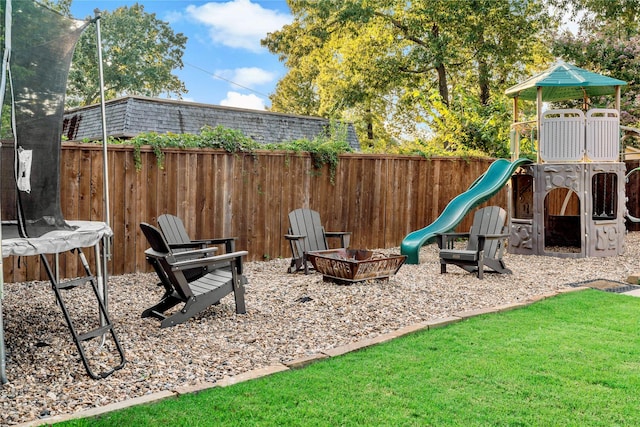 view of play area featuring a trampoline and a fire pit