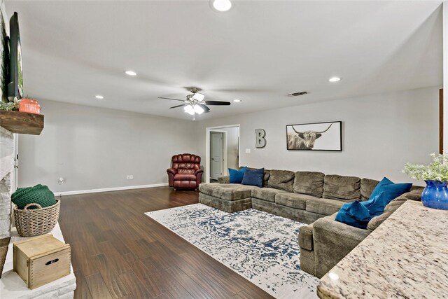 living room with ceiling fan, dark hardwood / wood-style flooring, and a fireplace