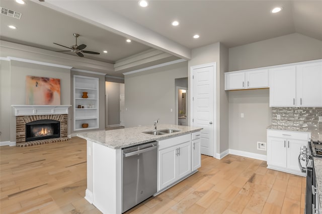 kitchen featuring stove, ceiling fan, sink, stainless steel dishwasher, and a fireplace