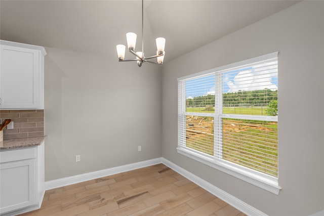 unfurnished dining area featuring light hardwood / wood-style flooring and a chandelier