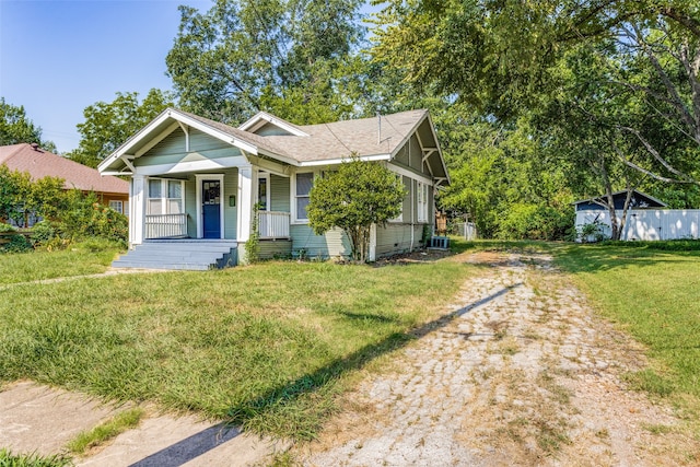 view of front facade featuring a porch, central air condition unit, and a front yard