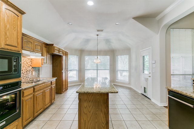 kitchen featuring black appliances, a healthy amount of sunlight, a kitchen island, and backsplash