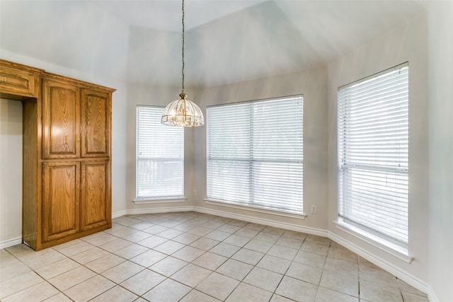 unfurnished dining area featuring lofted ceiling, a chandelier, and light tile patterned floors