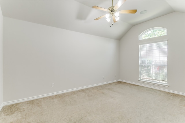 spare room featuring ceiling fan, light colored carpet, and lofted ceiling