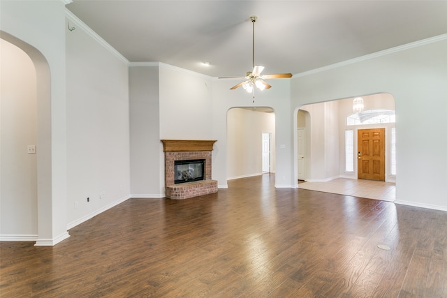 unfurnished living room featuring ceiling fan, a fireplace, hardwood / wood-style flooring, and crown molding