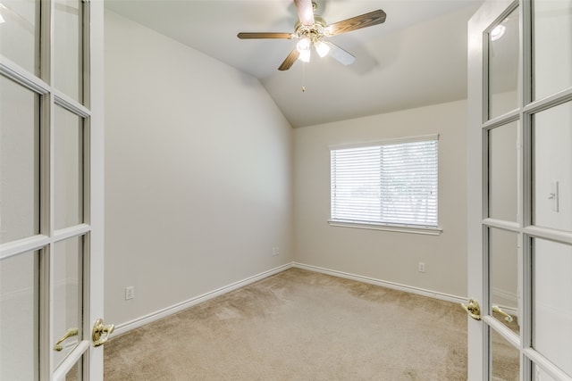 carpeted empty room featuring ceiling fan, french doors, and lofted ceiling