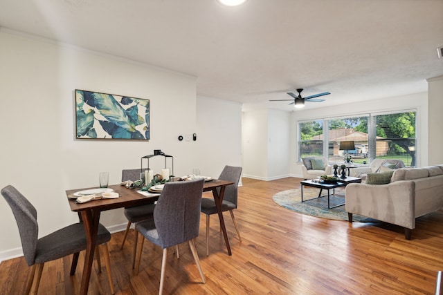 dining space featuring ceiling fan, crown molding, and light hardwood / wood-style flooring