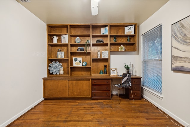 office featuring ceiling fan, dark wood-type flooring, and built in desk