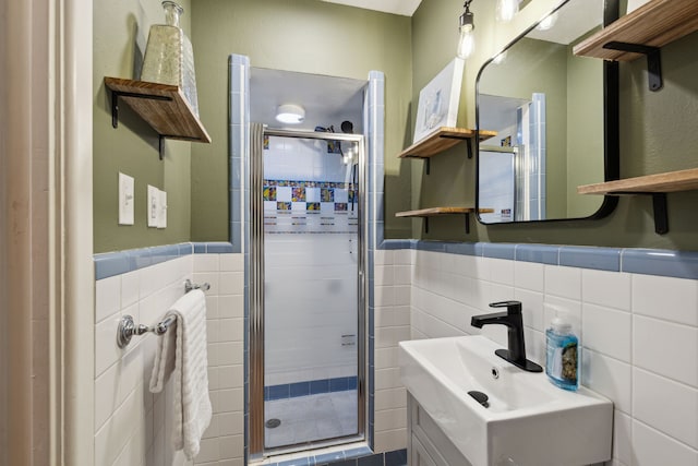 bathroom with backsplash, sink, a shower with door, and tile walls