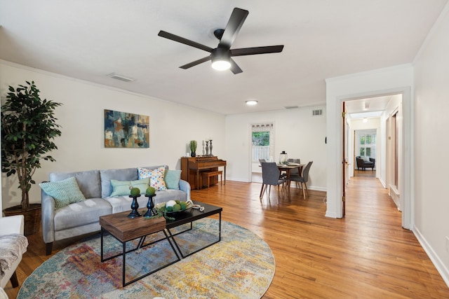 living room with light hardwood / wood-style floors, plenty of natural light, and ceiling fan