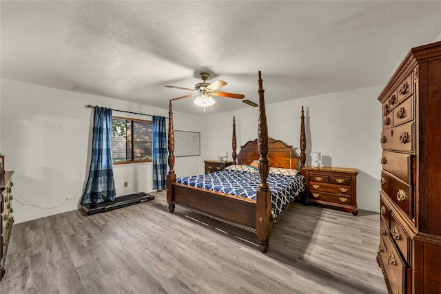 bedroom featuring wood-type flooring, a textured ceiling, and ceiling fan