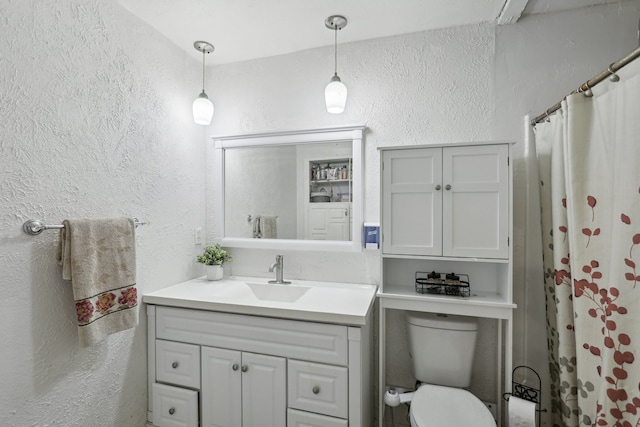 bathroom with vanity, toilet, and curtained shower