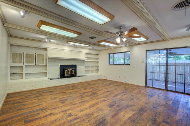 unfurnished living room with a fireplace, crown molding, built in shelves, ceiling fan, and wood-type flooring