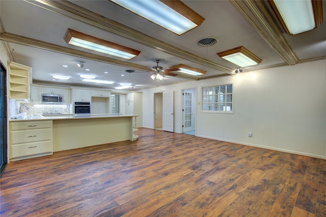 kitchen with ceiling fan, dark wood-type flooring, black oven, ornamental molding, and tasteful backsplash