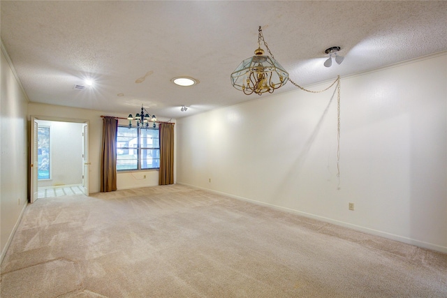 unfurnished room with a textured ceiling, ornamental molding, carpet flooring, and baseboards