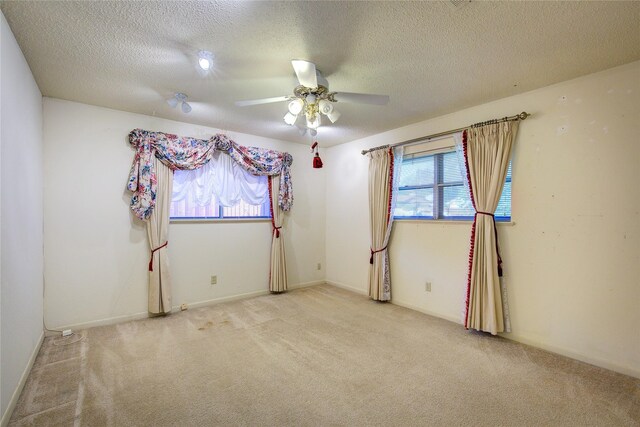 carpeted spare room with ceiling fan and a textured ceiling