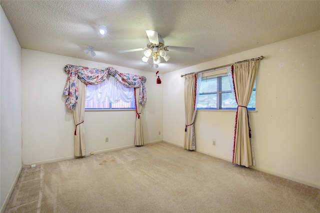 unfurnished room with light carpet, ceiling fan, and a textured ceiling