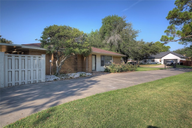 ranch-style home with driveway, a front yard, fence, and brick siding