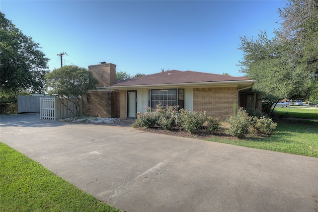 single story home featuring a front lawn