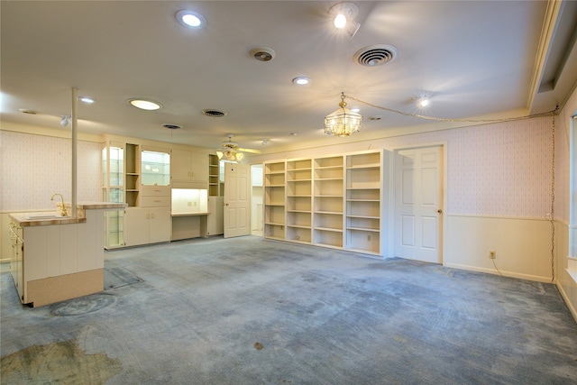 unfurnished living room featuring ceiling fan, sink, and carpet floors