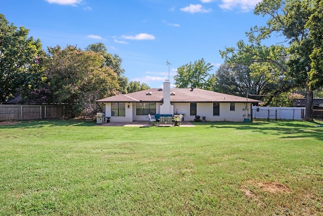 rear view of property featuring a yard and a patio area