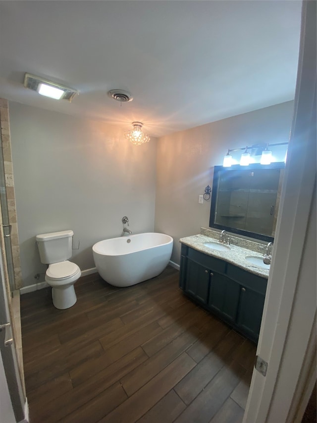 bathroom with hardwood / wood-style flooring, a shower, dual vanity, and toilet