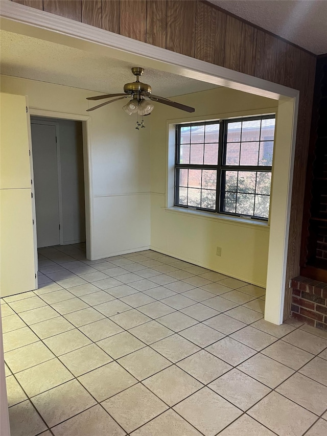 spare room featuring ceiling fan, a textured ceiling, and light tile patterned floors