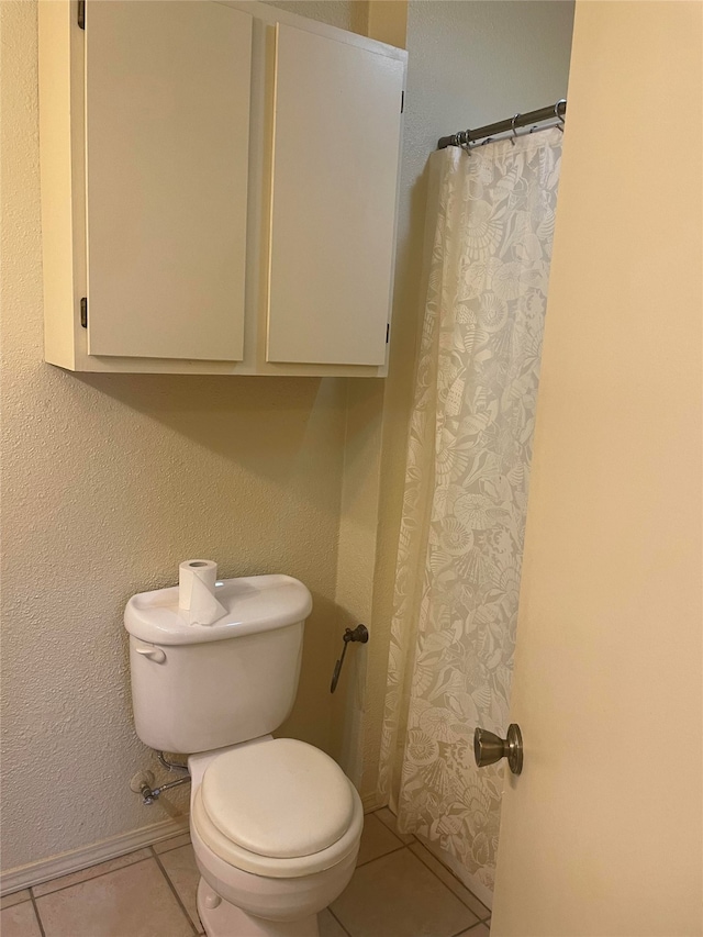 bathroom featuring toilet and tile patterned flooring