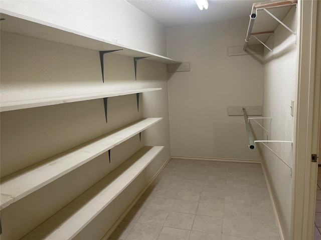 spacious closet featuring light tile patterned flooring