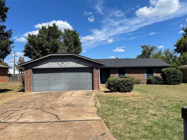 ranch-style home featuring a garage, concrete driveway, brick siding, and a front lawn