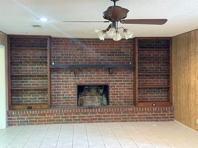 unfurnished living room featuring wood walls, brick wall, ceiling fan, and tile patterned flooring