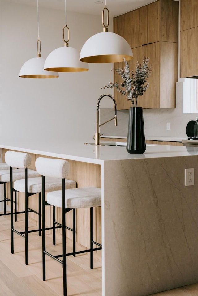 kitchen featuring pendant lighting, sink, and a breakfast bar area