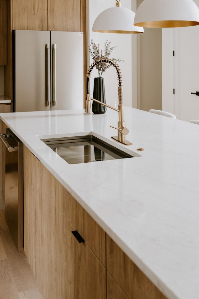 kitchen with sink, high quality fridge, dishwasher, and light wood-type flooring