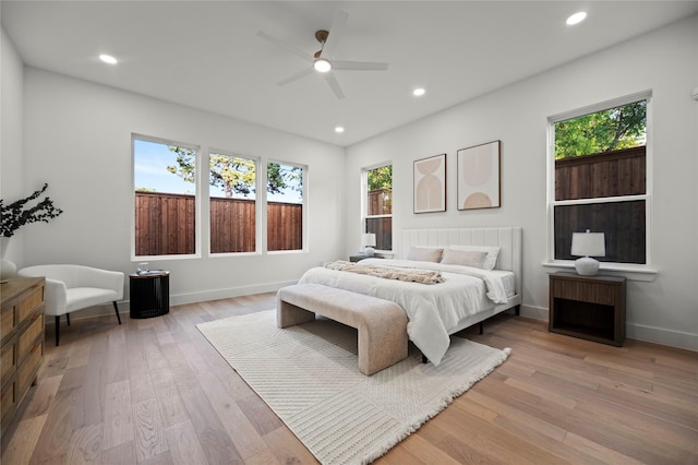 bedroom featuring multiple windows, ceiling fan, and light wood-type flooring